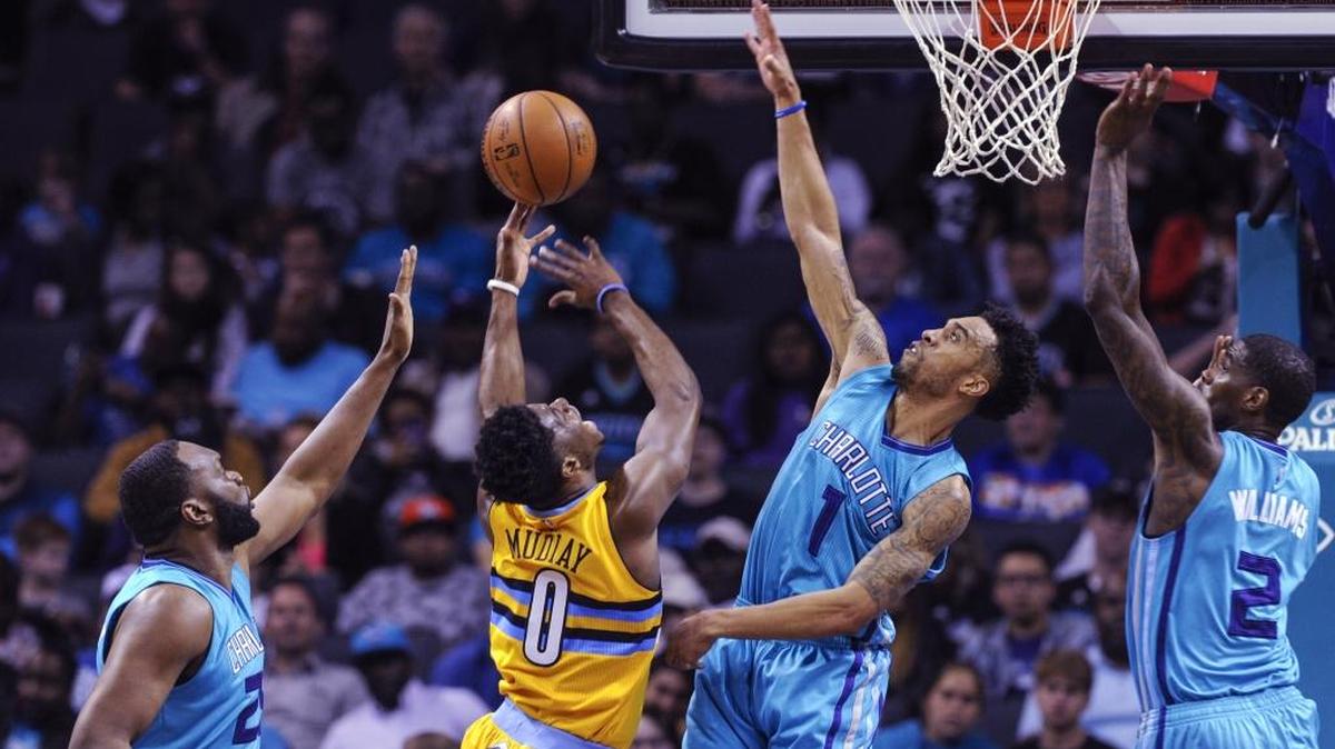 Denver Nuggets guard Emmanuel Mudiay (0) shoots against Charlotte Hornets' Courtney Lee (1) during the first half of an NBA basketball game in Charlotte, N.C., Saturday, March 19, 2016.