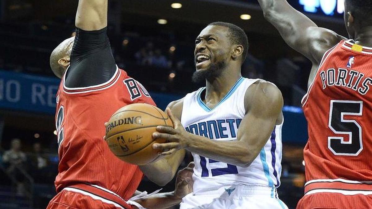 Charlotte Hornets guard Kemba Walker, center, drives against Chicago’s Taj Gibson, left, during Monday night's game.