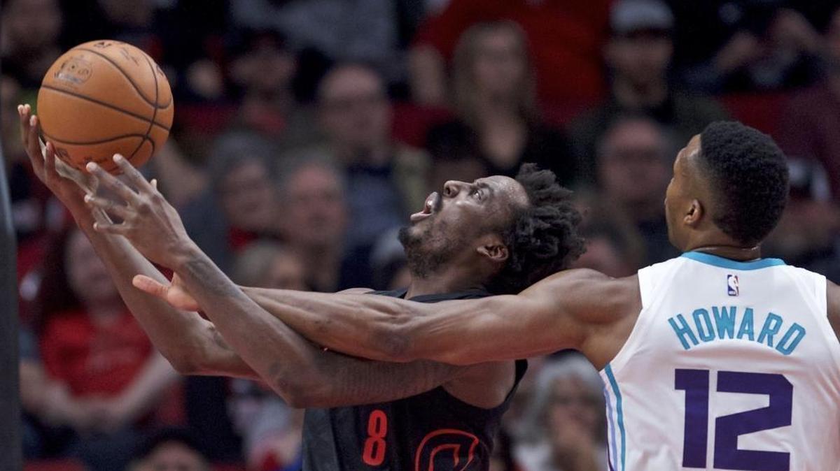 Portland Trail Blazers forward Al-Farouq Aminu, left, is fouled by Charlotte Hornets center Dwight Howard during the first half of Thursday’s game in Portland, Ore.