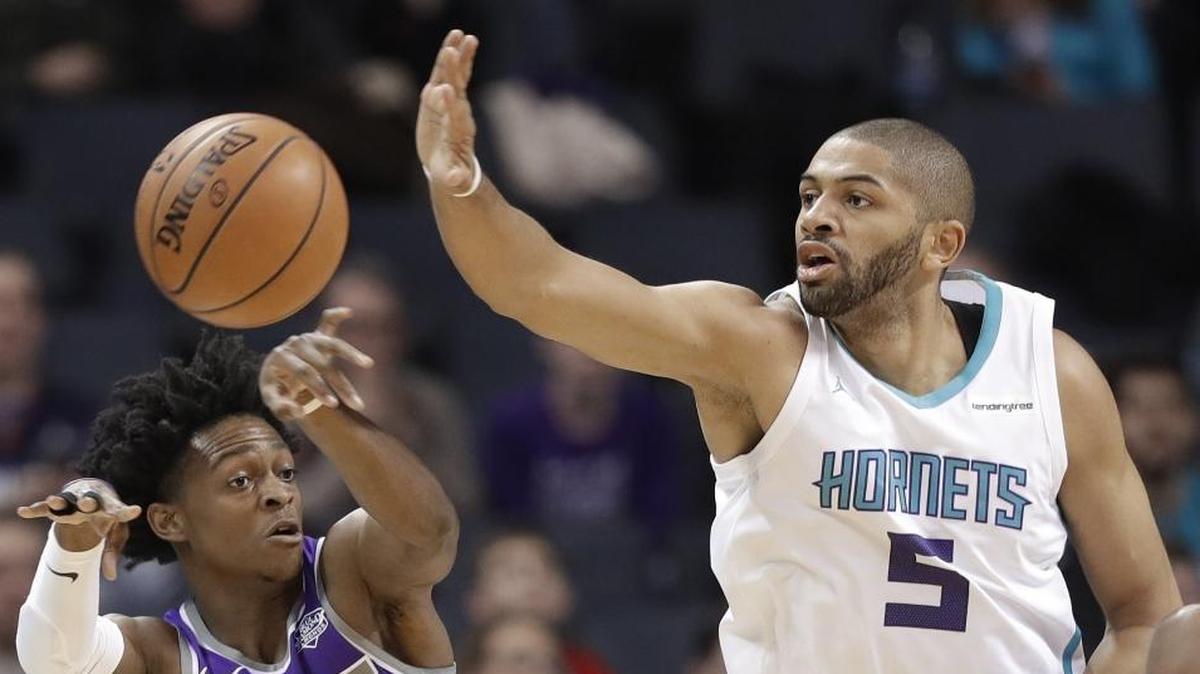 Sacramento Kings' De'Aaron Fox, left, passes the ball past the Charlotte Hornets' Nicolas Batum during the first half of Monday’s NBA game at Spectrum Center.