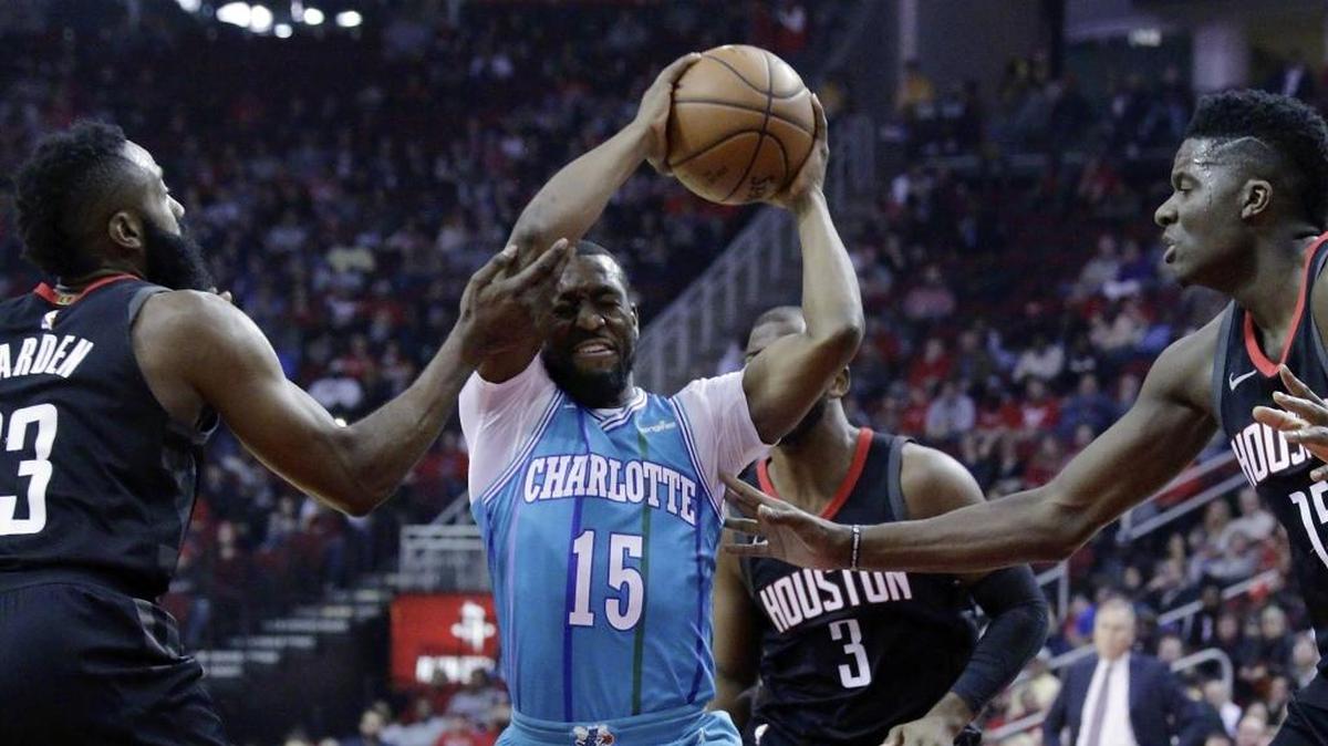 Charlotte Hornets guard Kemba Walker (15) looks to pass, surrounded by Houston Rockets in the first half of Wednesday’s game.