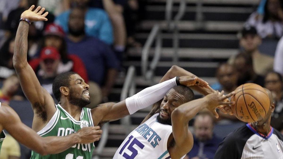 Charlotte Hornets guard Kemba Walker (15) gets fouled by Boston Celtics' Kyrie Irving (11) in the first half of Wednesday’s preseason game