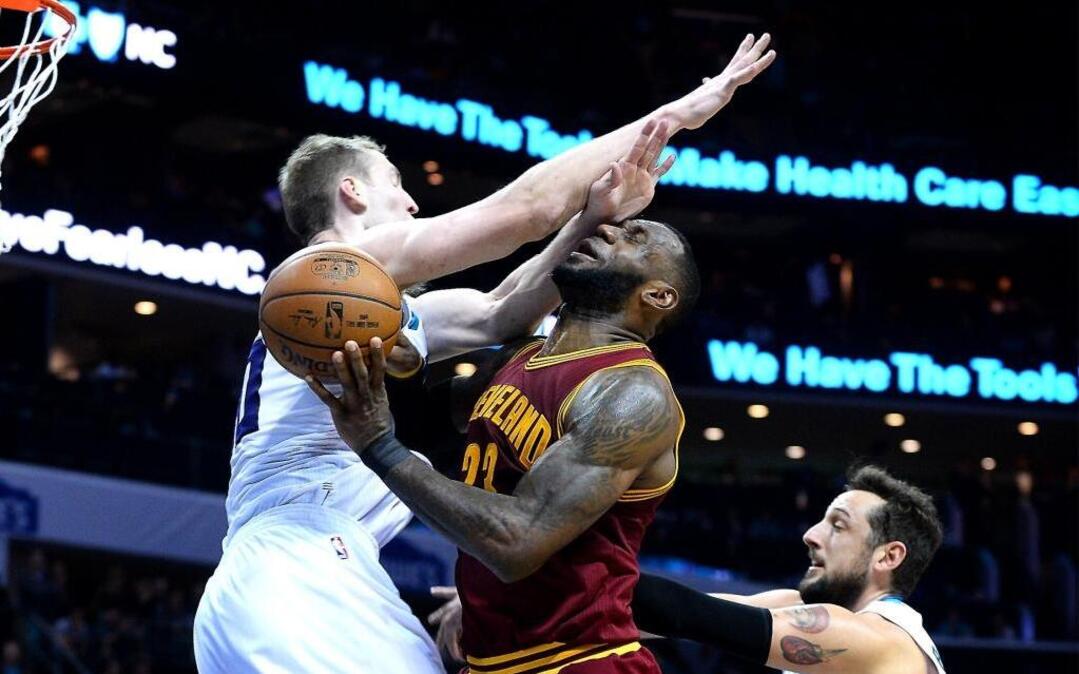 Cleveland Cavaliers forward LeBron James, center, is fouled by Charlotte Hornets center Cody Zeller, left, during the second half of Friday’s game at the Spectrum Center . The Cavaliers defeated the Hornets 112-105.