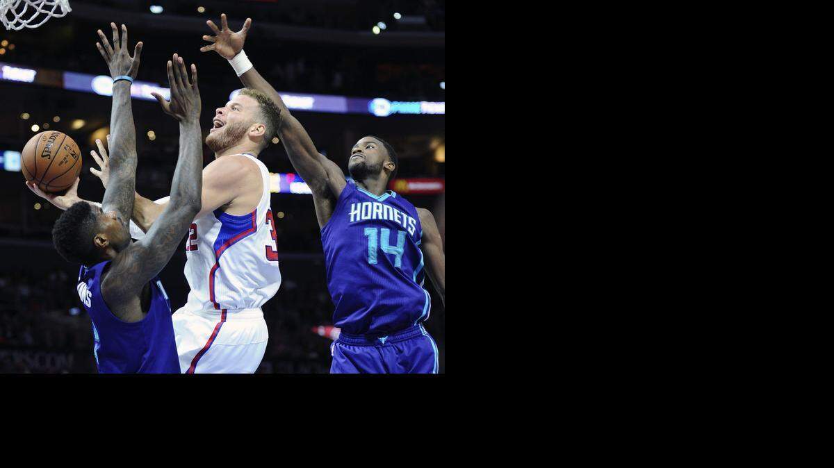 
The Los Angeles Clippers' Blake Griffin scores between the Charlotte Hornets' Marvin Williams, left, and Michael Kidd-Gilchrist at Staples Center in Los Angeles on Tuesday, March 17, 2015.
