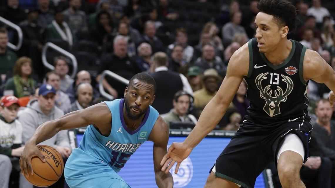 Charlotte Hornets guard Kemba Walker, left, drives against the Milwaukee Bucks' Malcolm Brogdon during the first half of Friday’s NBA game in Milwaukee. The Bucks won 108-99.