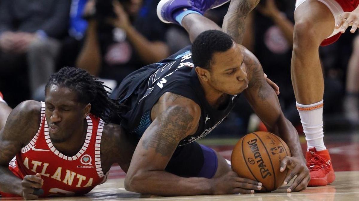 Charlotte Hornets forward Treveon Graham (21) and Atlanta Hawks forward Taurean Prince (12) dive for a loose ball during the first half Wednesday at Spectrum Center.