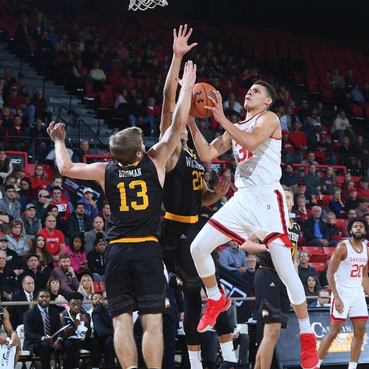 Kellan Grady (31) of Davidson drives against Winthrop’s Bjorn Broman (13) and Josh Ferguson (25) at Belk Arena on Tuesday in Davidson.