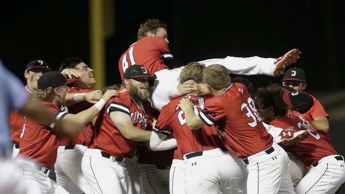 Davidson's Will Robertson (41) jumps onto teammates after the Wildcats defeated North Carolina 2-1 in Sunday’s game against Chapel Hill Regional host North Carolina. Davidson, in its first-ever NCAA baseball tournament, will advance to the super regional.
