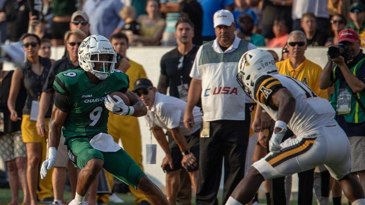 Charlotte 49ers receiver Victor Tucker (left) picks up yardage against Appalachian State in 2018.