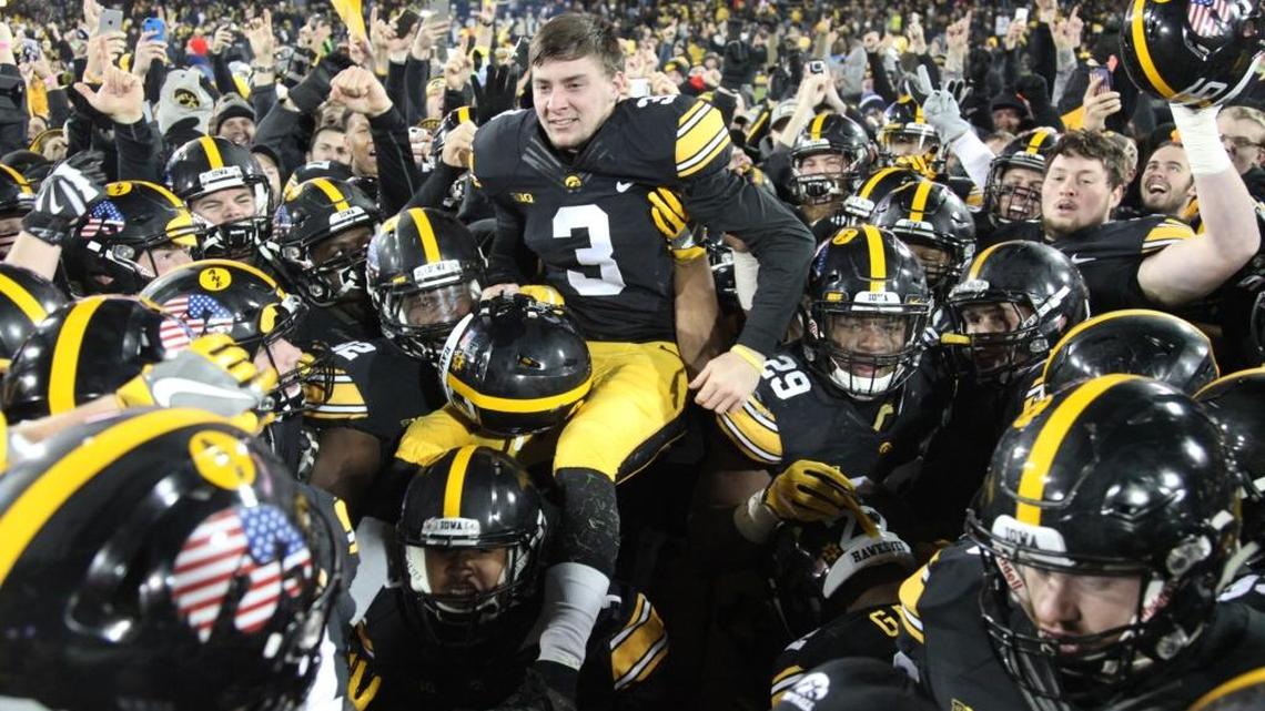 Weddington High alumnus Keith Duncan (3) is lifted in the air by his Iowa Hawkeyes teammates after kicking the winning field goal against the Michigan Wolverines on Saturday.
