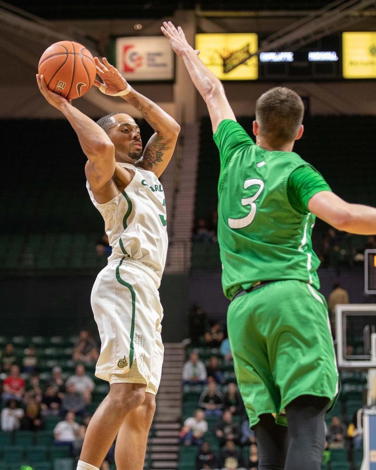 Charlotte 49ers senior guard Jon Davis, left, is defended by Marshall’s Jansson Williams during Saturday’s Conference USA men’s basketball game at Halton Arena.
