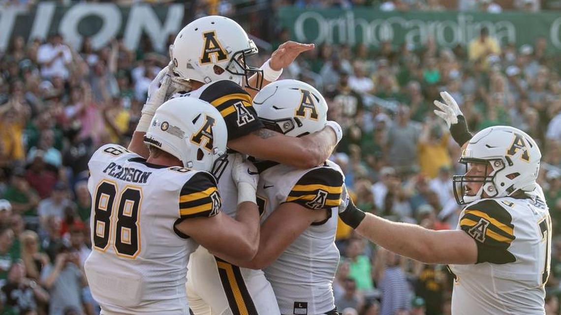 Appalachian State quarterback Zac Thomas celebrates with teammates after scoring on a 5-yard touchdown in the first quarter of Saturday’s college football game against the Charlotte 49ers. Thomas also completed all 14 of his passes for 295 yards and three touchdowns in the Mountaineers’ 45-9 win at Richardson Stadium.