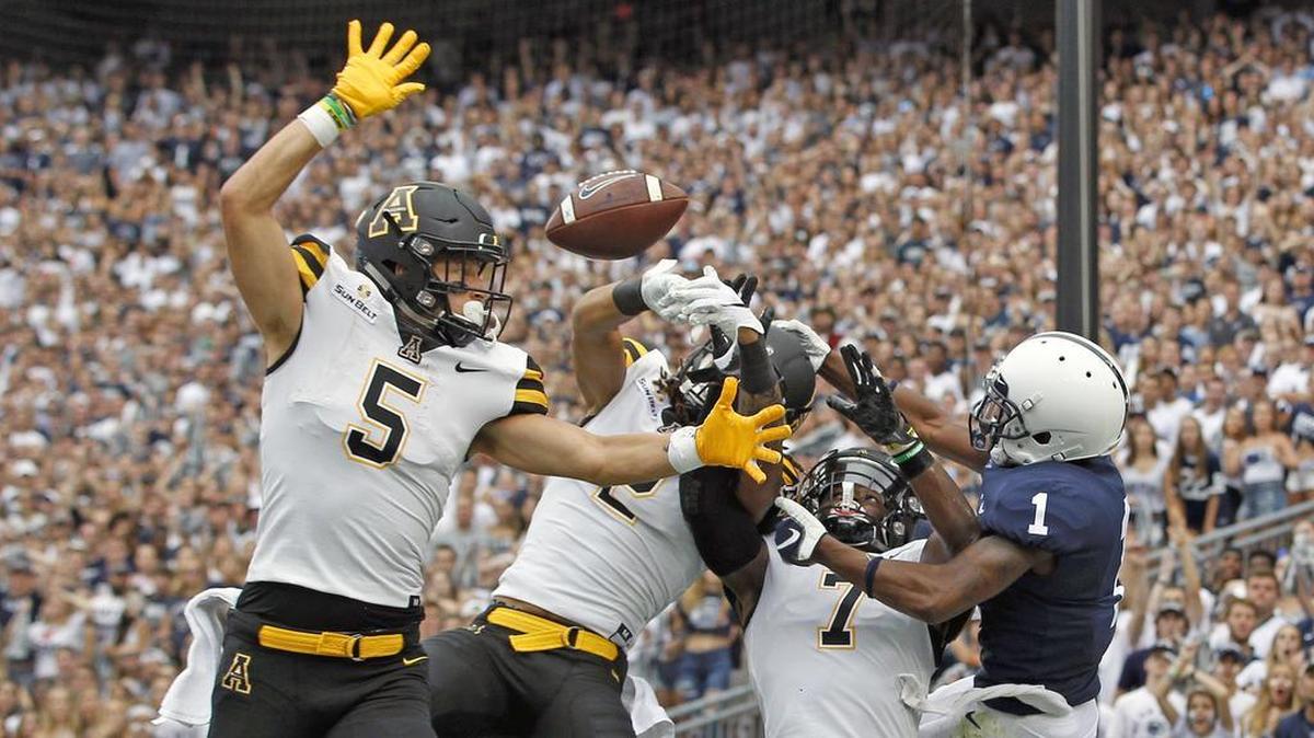 Appalachian State’s Thomas Hennigan (5), Corey Sutton and Josh Thomas (7), break up a pass in the end zone for Penn State’s KJ Hamler.