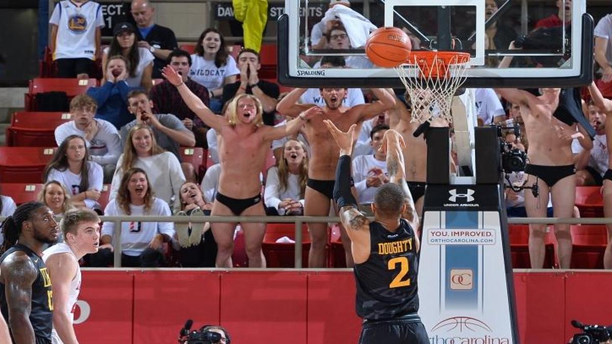 Members of the Davidson swim team try to distract VCU’s Samir Doughty (02) as he tries to hit free throws late in the second half of Saturday’s game at Belk Arena. Davidson won 69-63.
