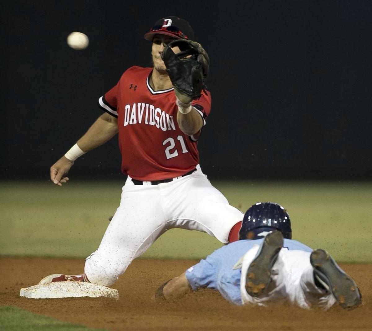 Davidson shortstop Max Bazin (21) waits on the throw from the catcher as North Carolina’s Brandon Riley tries to steal second base in the fourth inning of their NCAA regional final Sunday at Boshamer Stadium in Chapel Hill.