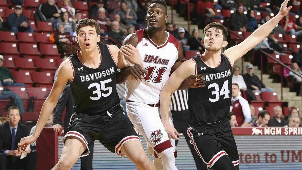 Massachusetts’ Djery Baptiste, center, battles for position with Davidson's Luka Brajkovic, left, and Luke Frampton during Saturday’s Atlantic 10 men’s basketball game in Amherst, Mass. UMass won 54-51.