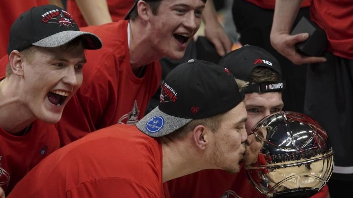 Davidson forward Peyton Aldridge kisses the trophy as he celebrates with teammates after winning the Atlantic 10 tournament Sunday over Rhode Island.