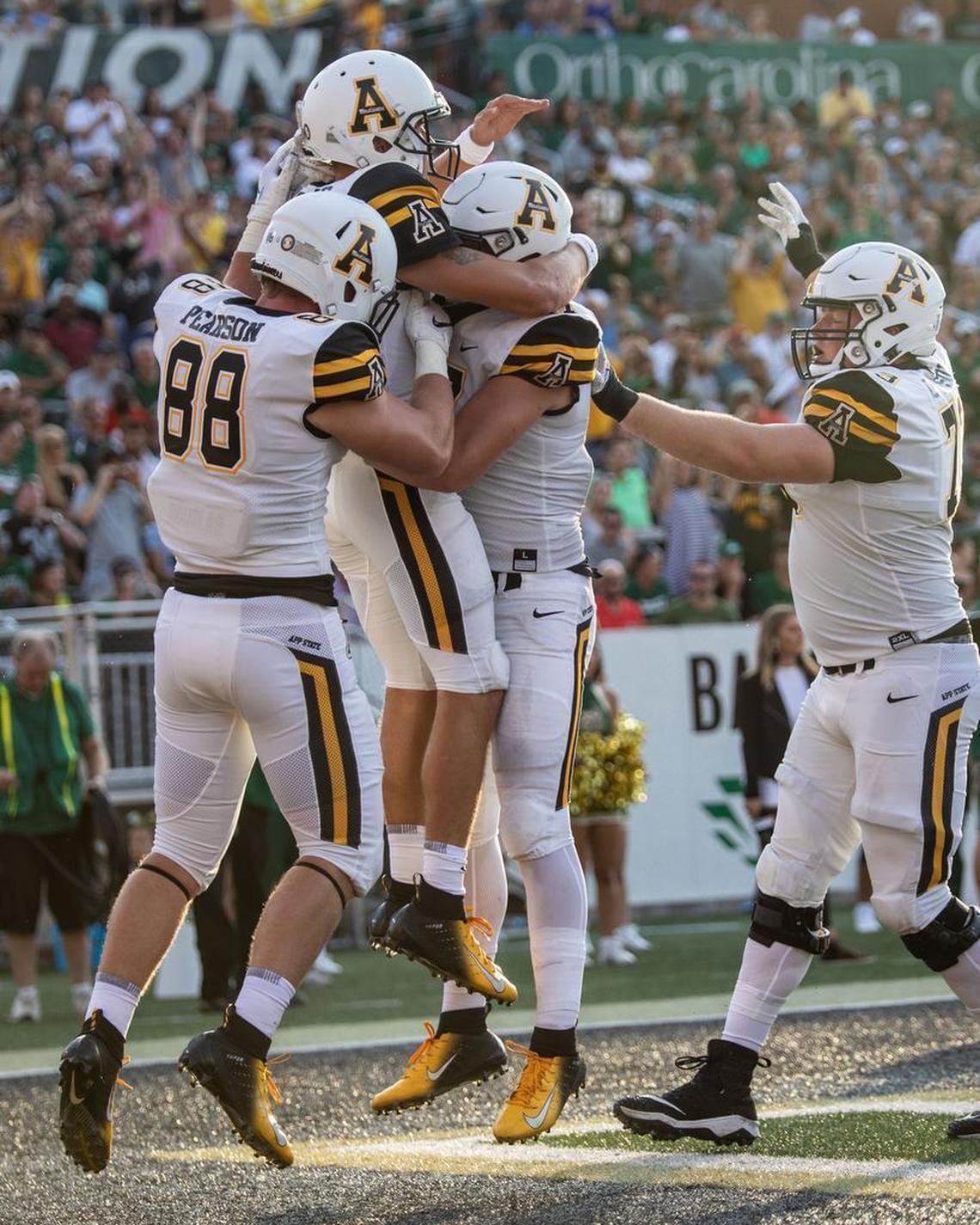 App State quarterback Zac Thomas is congratulated by teammates after scoring on a 5-yard touchdown late in the first quarter against the Charlotte 49ers at Richardson Stadium. Thomas and the Mountaineers won 45-9.