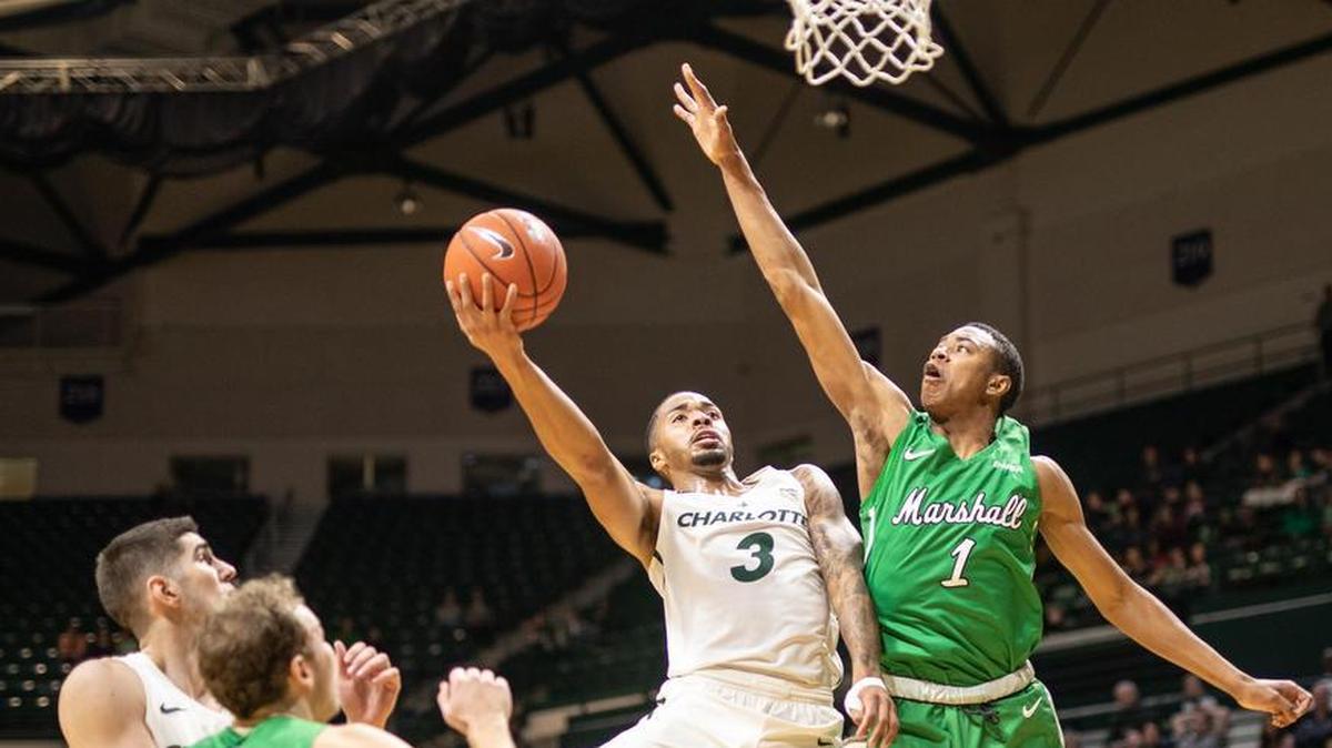 Charlotte 49ers senior guard Jon Davis (3) is defended by Marshall’s Taevion Kinsey (1) during Saturday’s Conference USA men’s basketball game at Halton Arena.
