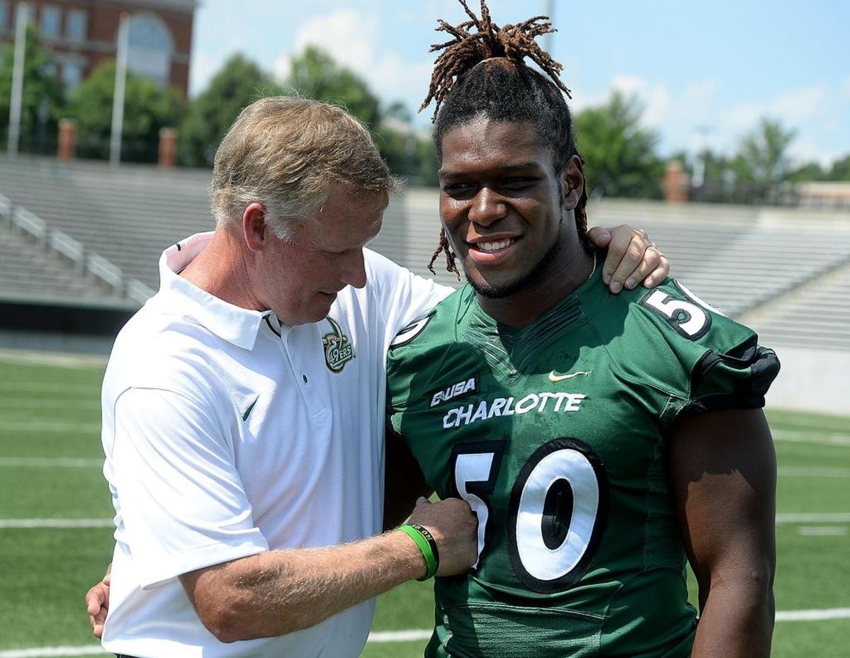 Charlotte 49ers football coach Brad Lambert and linebacker Karrington King get ready for a photo during Saturday’s media day.