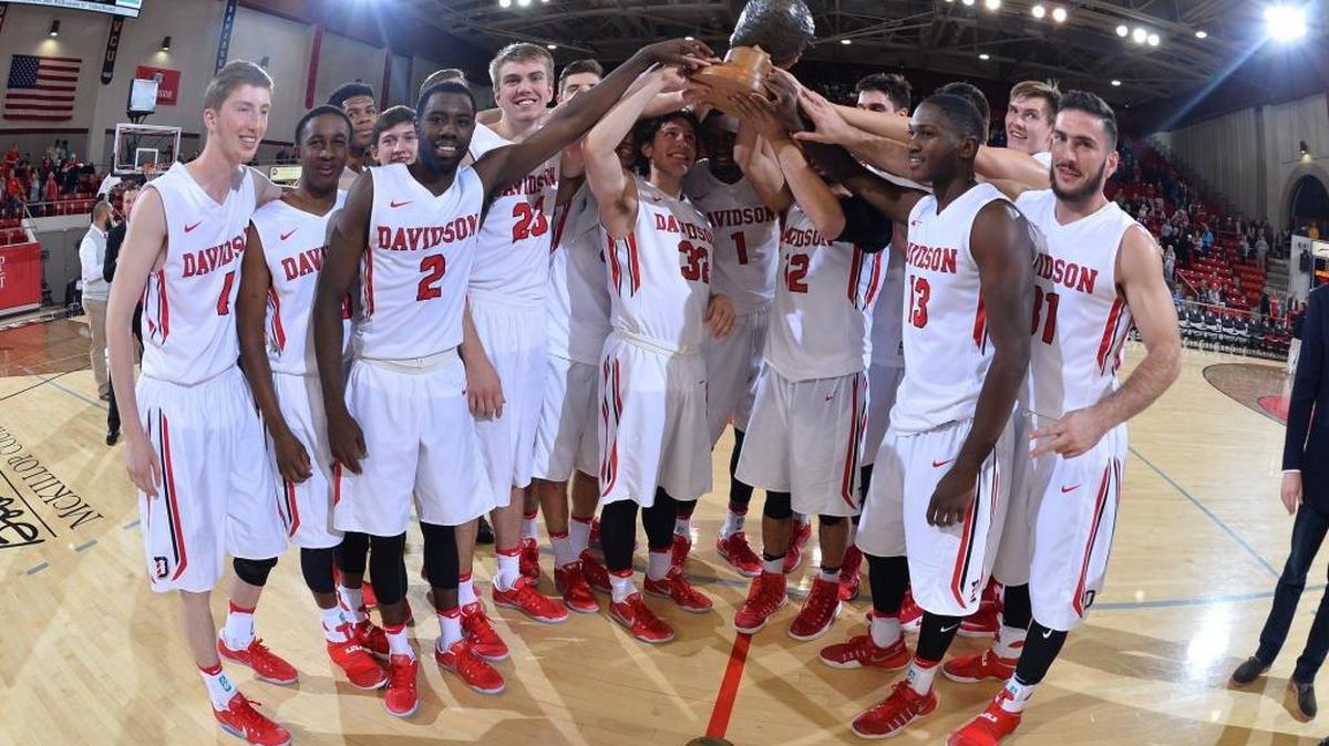 Davidson players hold the Hornet’s Nest Trophy aloft after beating the Charlotte 49ers 79-57 in 2016.