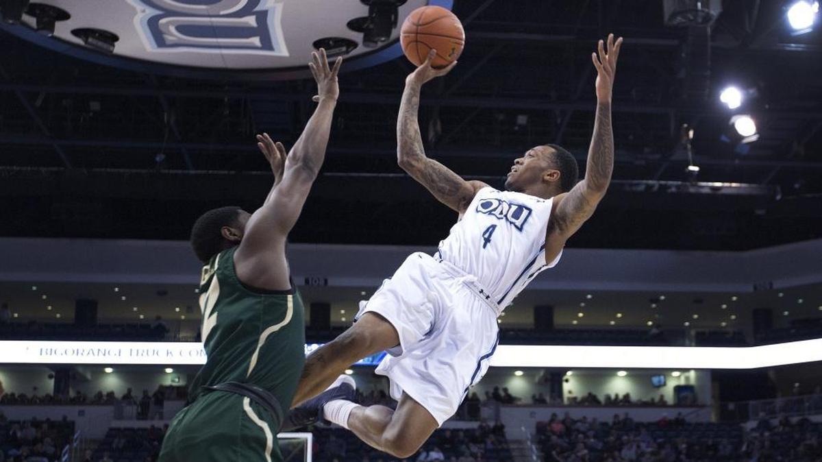 Old Dominion's Ahmad Caver (4) scores and is fouled by Charlotte’s Jaylan McGill in the Monarchs’ 89-58 victory against the 49ers on Saturday.