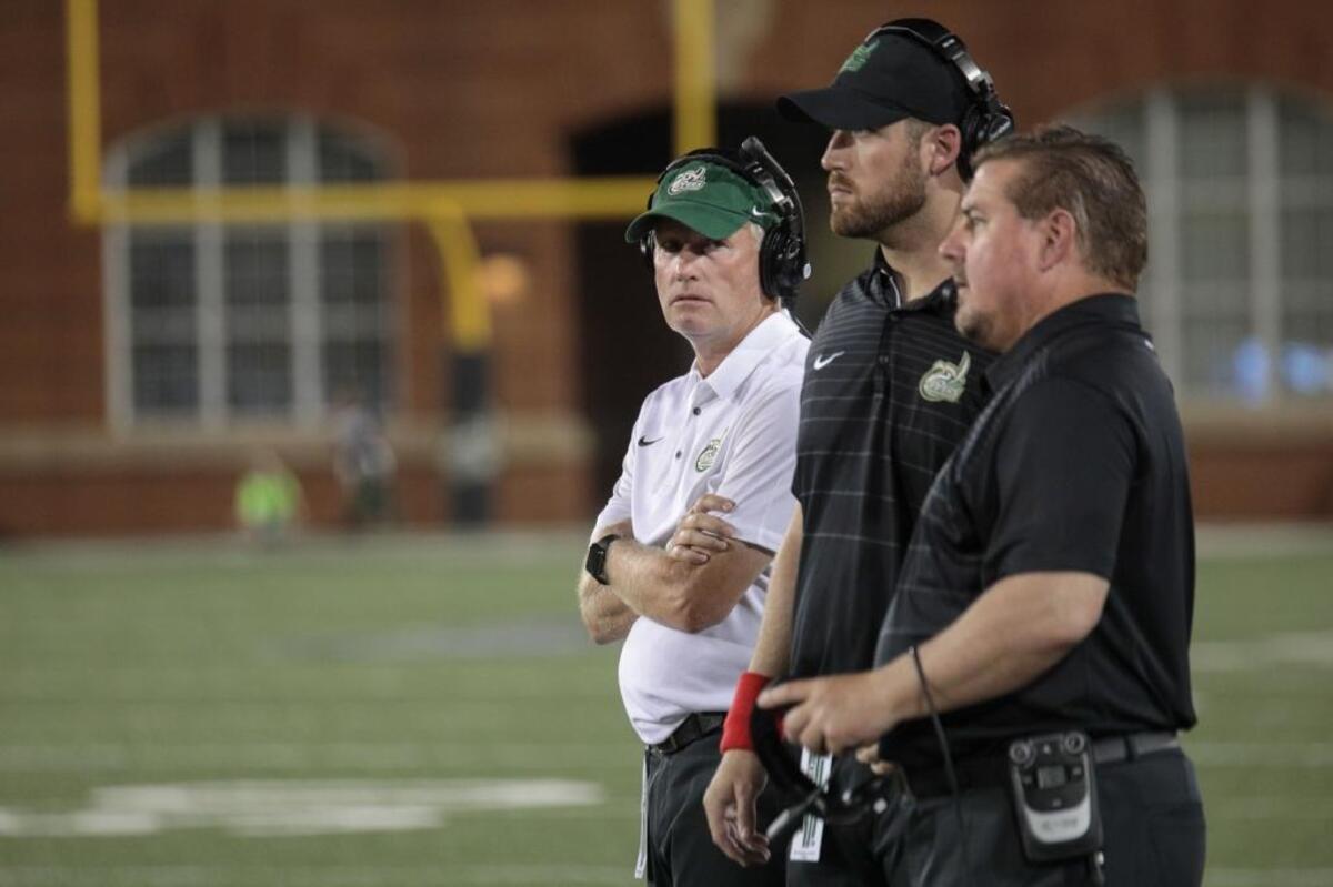 Charlotte 49ers coach Brad Lambert, left, and assistants Johnson Richardson and Matt Walllerstedt, watch Saturday’s game against visiting Georgia State.