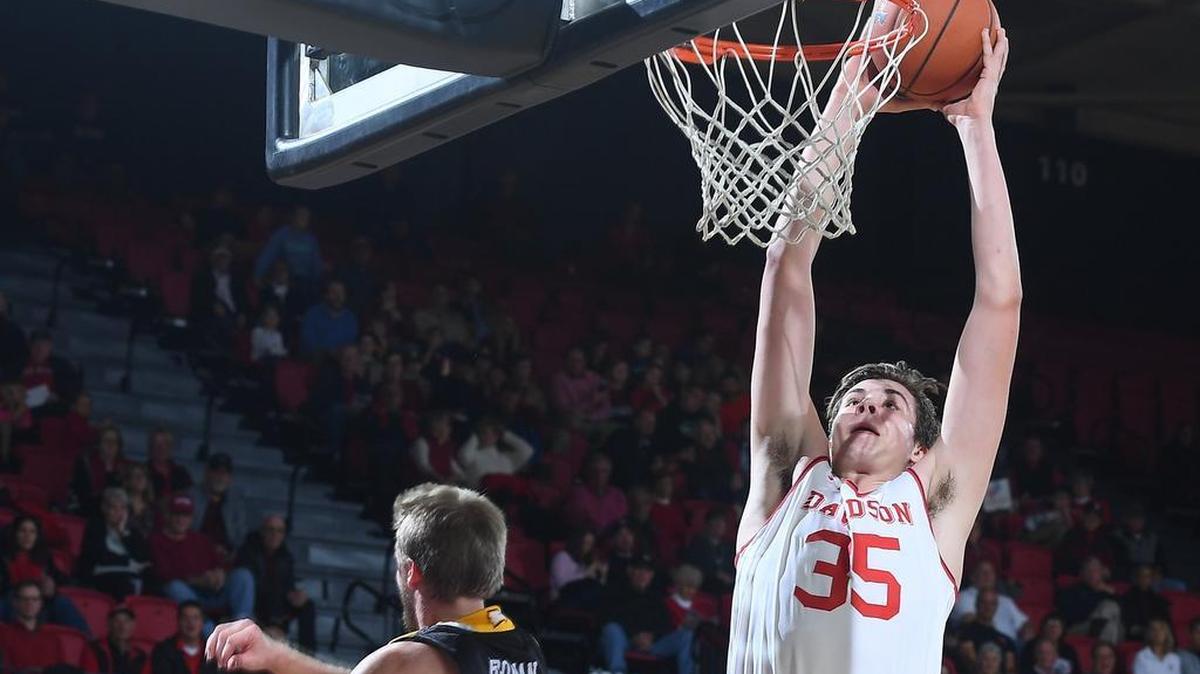 Davidson freshman Luka Brajkovic dunks over Winthrop’s Bjorn Broman for two of his first-half 10 points. Brajkovic finished with 18 points in the Wildcats’ 99-81 nonconference victory.