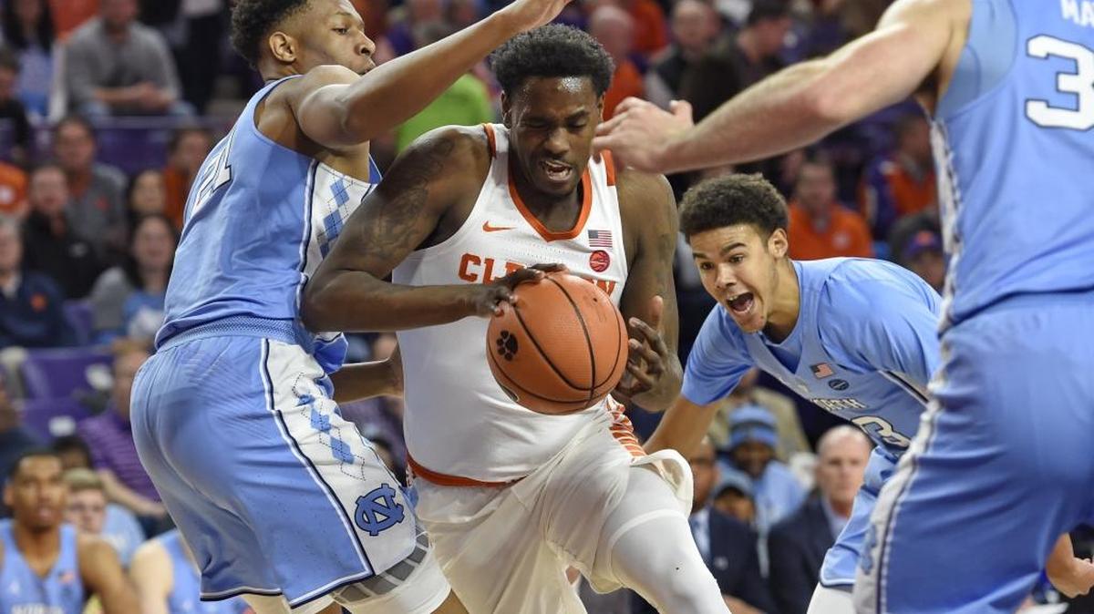Clemson's Elijah Thomas (center) drives between North Carolina defenders, including Sterling Manley (left), during the first half of the Tigers’ victory Tuesday.