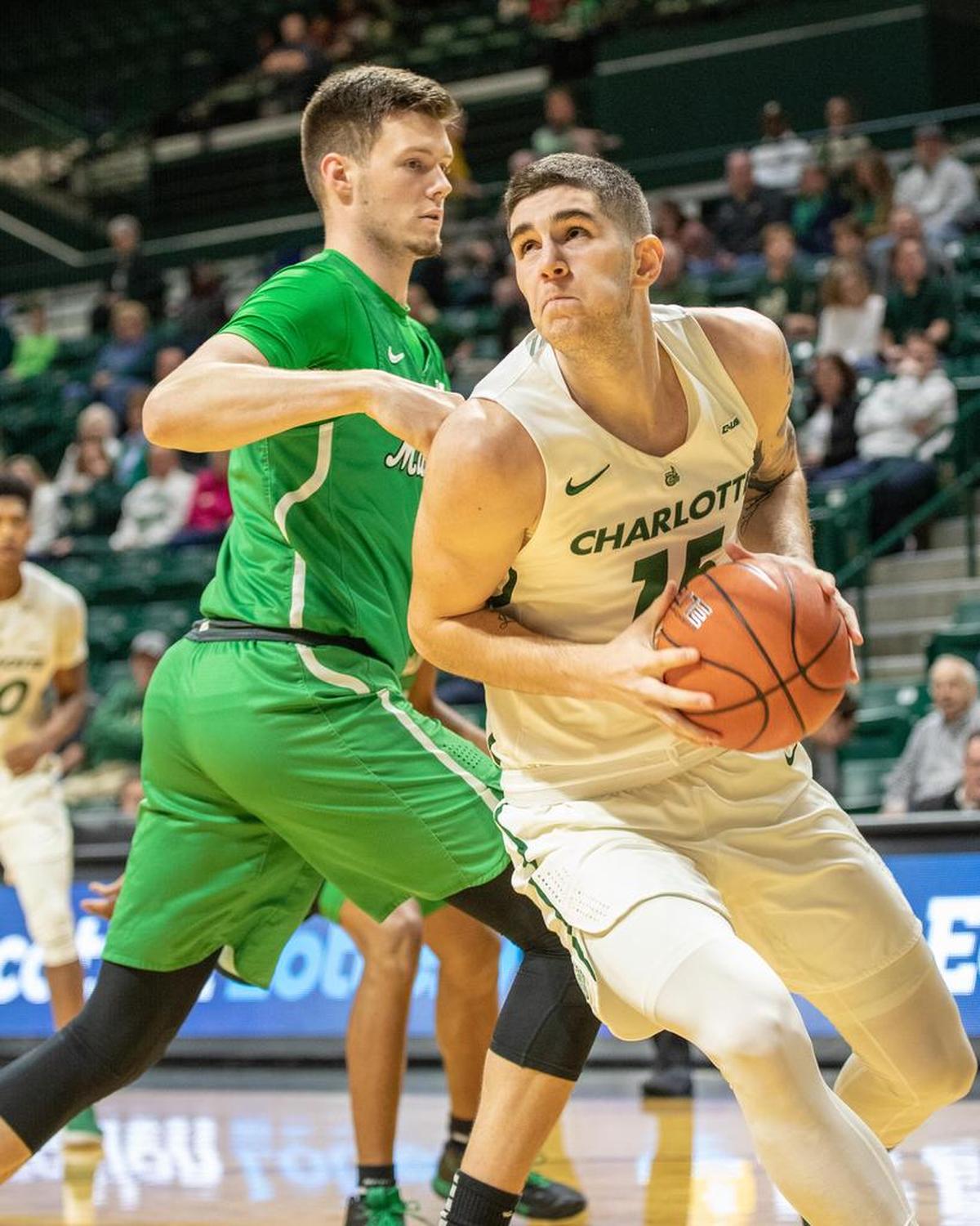 Charlotte 49ers sophomore forward Milos Supica, right, drives to the basket against Marshall in the first half of Saturday’s Conference USA men’s basketball game at Halton Arena. He finished with a career-high 23 points.