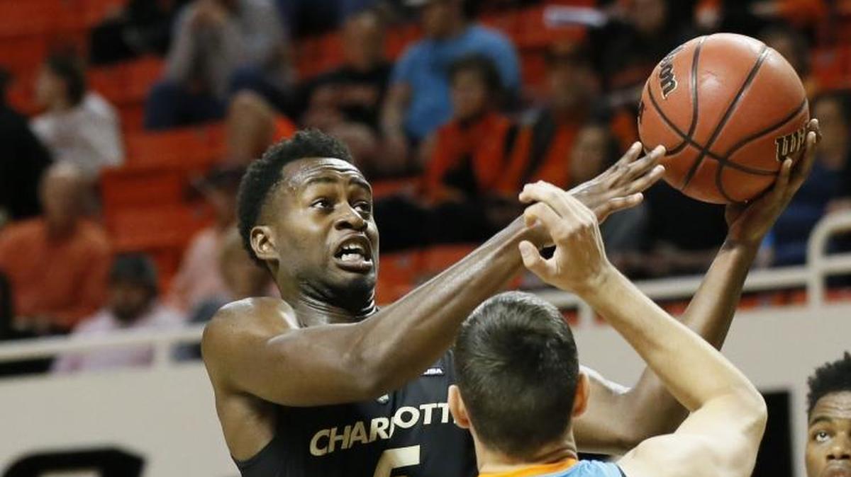 Charlotte 49ers guard Austin Ajukwa (5) shoots in front of Oklahoma State's Thomas Dziagwa (4) and Charlotte's Jailan Haslem (0) during the first half of Monday’s game in Stillwater, Okla.