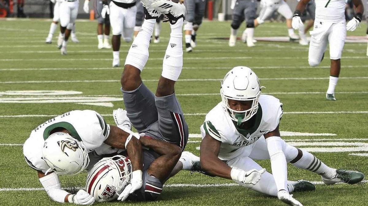 Massachusetts’ Brennon Dingle (center) catches the ball at the 49 as the Charlotte 49ers’ Ed Rolle (right) and Denzel Irvin defend in the first quarter of Saturday’s college football game in Amherst, Mass. The host Minutemen won 49-31.