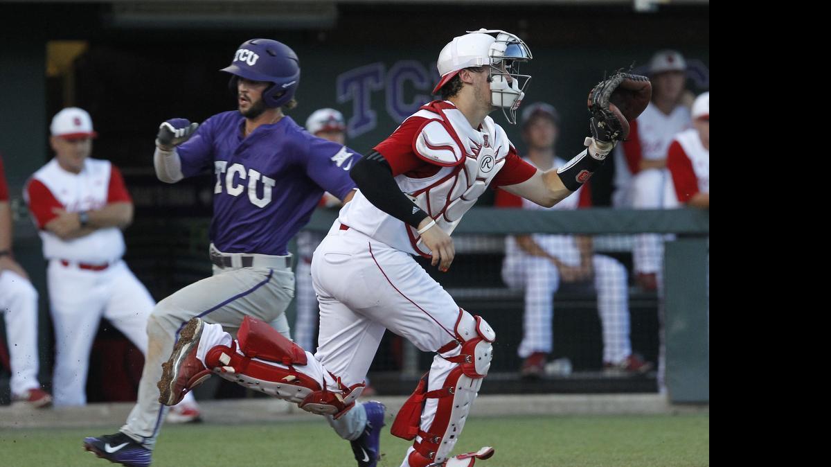 
TCU's Garrett Crain, left, runs past NC State catcher Andrew Knizner (11) to score in the third inning at the Fort Worth Regional of the NCAA college baseball tournament. 
