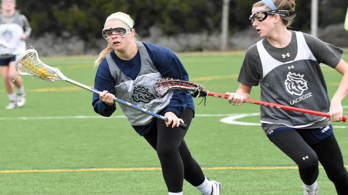 Queens senior attacker Maggie Masters, left, gets past a defending teammate in a drill during the Royals’ women’s lacrosse practice Jan. 26 at the Queens Sports Complex in Charlotte. Queens is picked to win its third straight South Atlantic Conference title this season.
