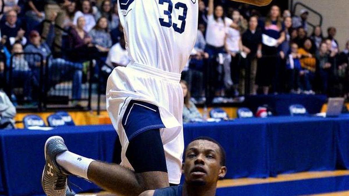 Todd Withers soars to the basket for a dunk for Queens over Lincoln Memorial’s Cornelius Taylor during the first half of Tuesday night’s game at Queens. Lincoln Memorial won 82-68.