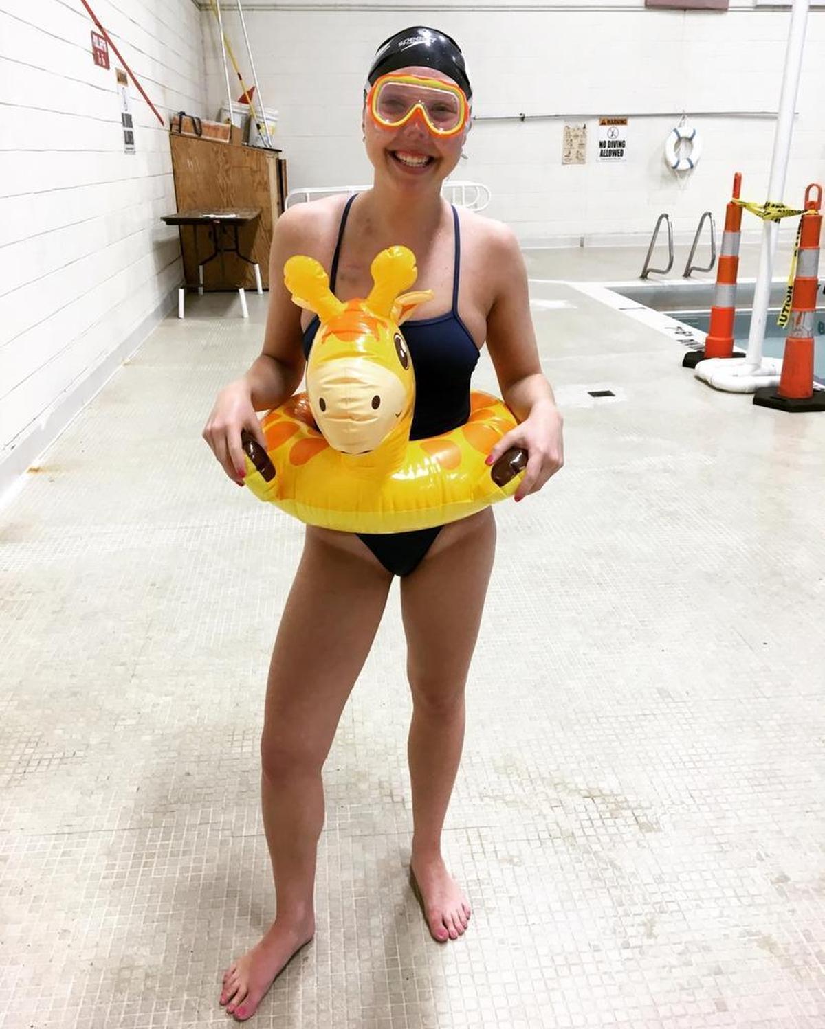 Right before getting back into the pool for the first time since her cancer diagnosis, Alexandra Marshall put on big goggles, a kids’ inner tube and a huge grin to pose for this photo she texted to her coaches at Queens.