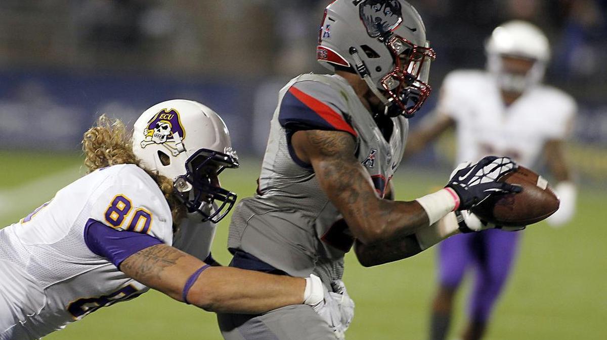 Connecticut Jamar Summers, right, intercepts an East Carolina pass during the second quarter of their game in East Hartford, Conn.