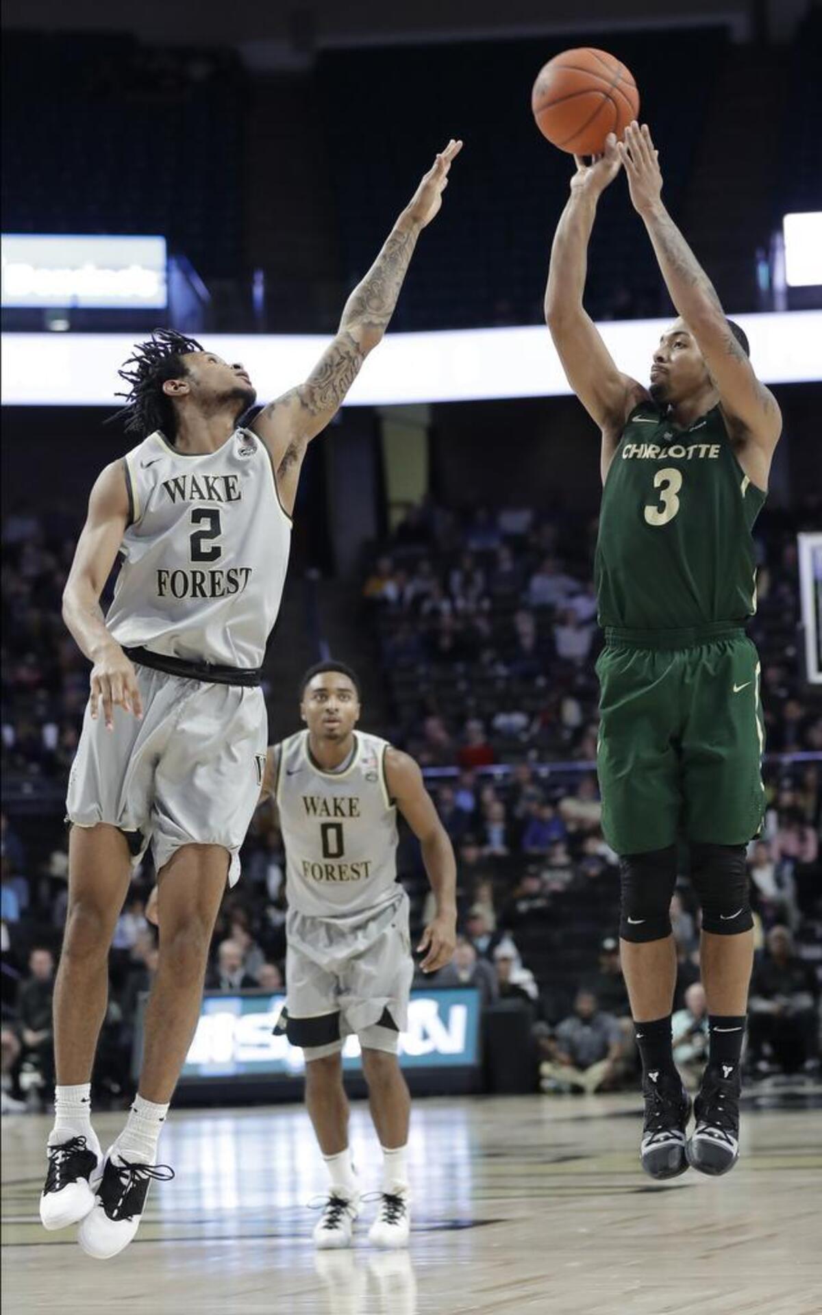 Charlotte's Jon Davis, right, shoots over Wake Forest's Sharone Wright Jr. in the second half of Thursday’s college basketball game in Winston-Salem. Davis finished with a team-high 21 points in the 49ers’ 80-56 loss to the Deacons.