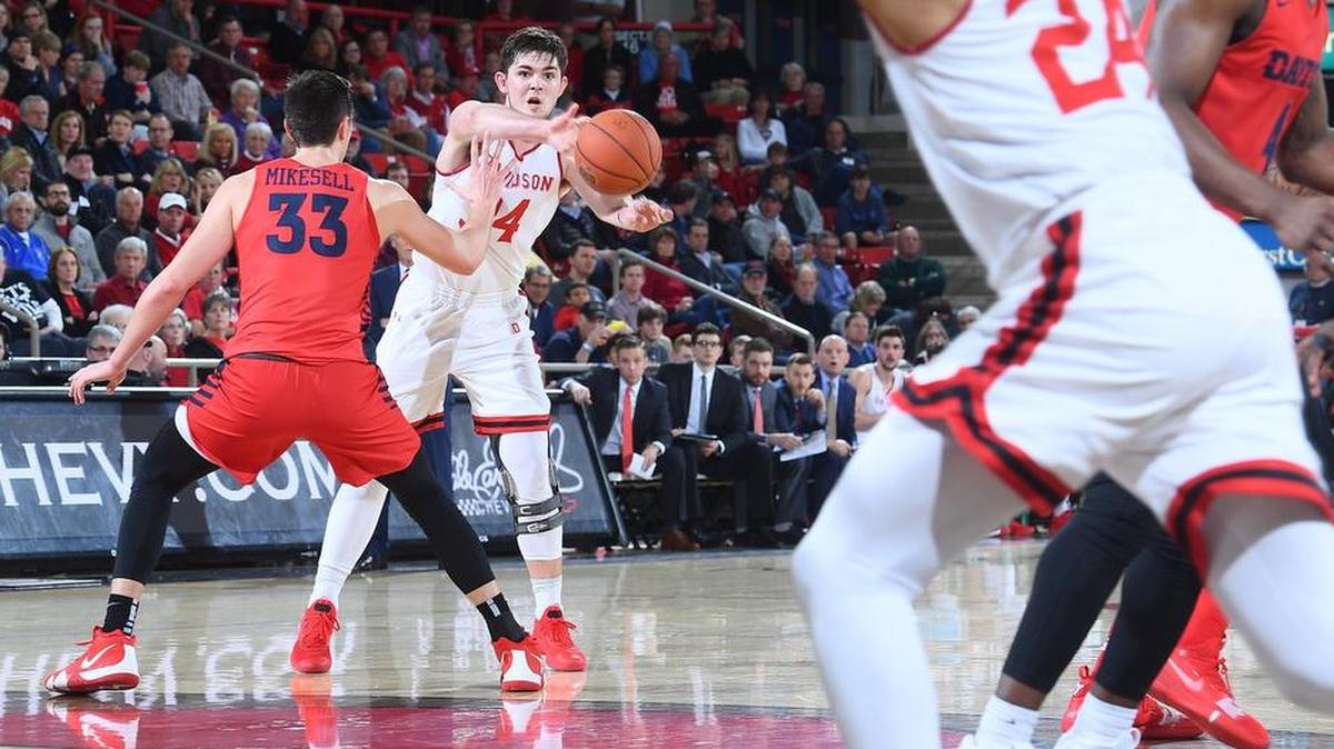 Luke Frampton (34) of Davidson looks to pass to teammate Carter Collins (24) around Ryan Mikesell (33) of Dayton late in the first half Davidson’s A-10 basketball game at Belk Arena on Tuesday at Davidson.