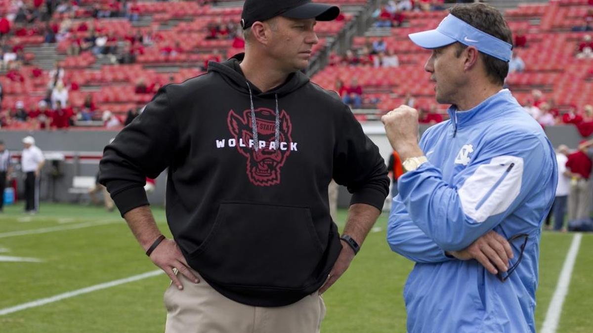 N.C. State coach Dave Doeren, left, and North Carolina coach Larry Fedora chat prior to their 2015 game at Carter Finley Stadium. The prospect of divisional realignment did not come up when ACC coaches met this week.
