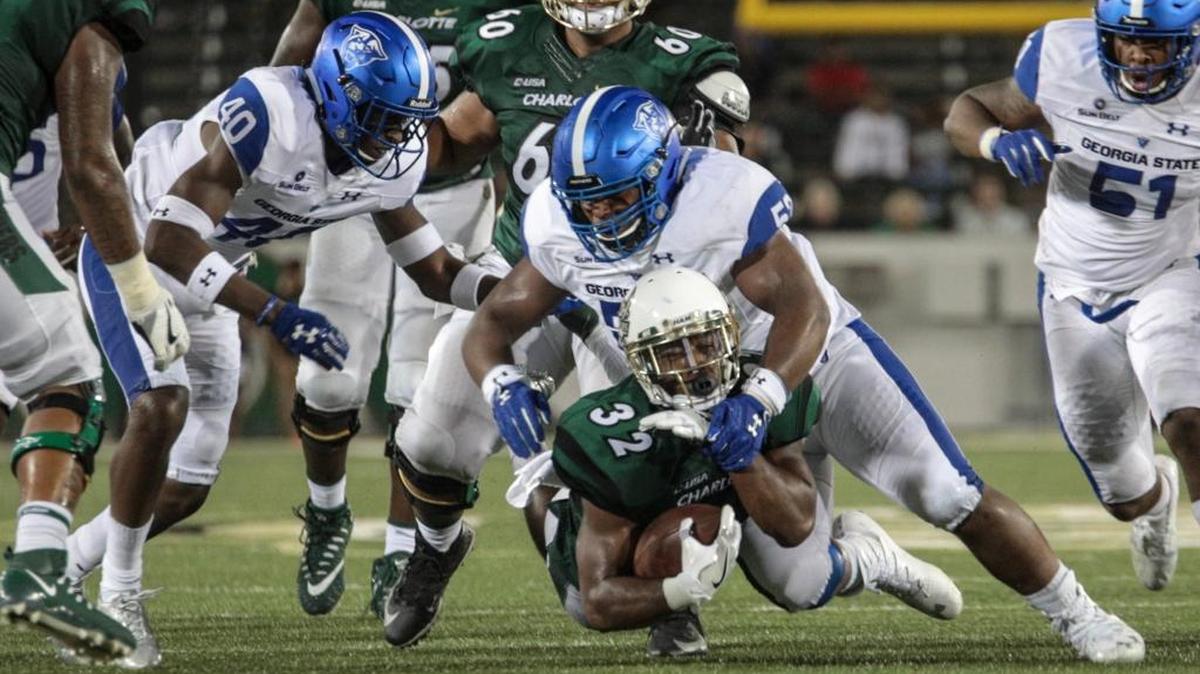 Charlotte 49ers running back Benny LeMay (32) gets dragged down by Georgia State defenders during Saturday’s college football game at Richardson Stadium.