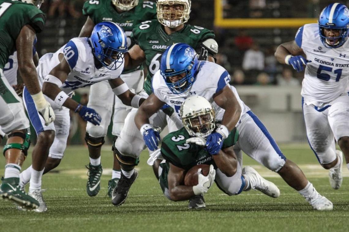 Charlotte 49ers running back Benny LeMay (32) gets dragged down by Georgia State defenders during Saturday’s college football game at Richardson Stadium.