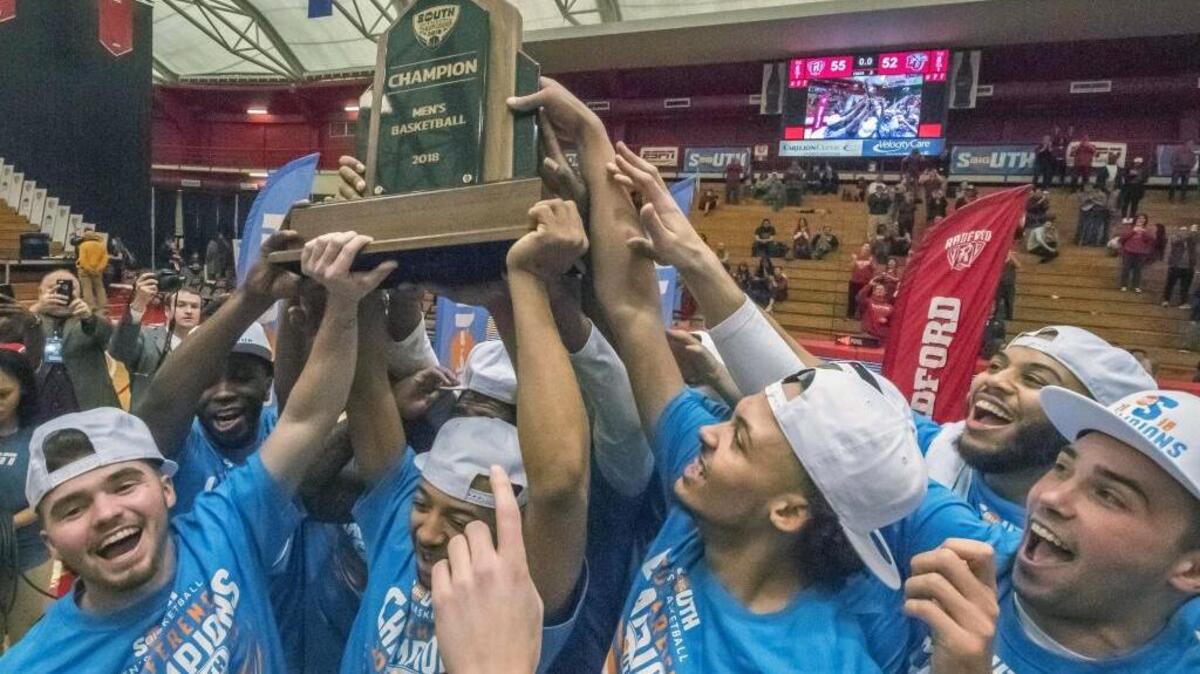 Radford players, from left to right, Caleb Tanner, Carlik Jones, Devonnte Holland, Darius Bolstad and John Caldwell celebrate with the championship trophy after Sunday’s Big South Conference win over Liberty.