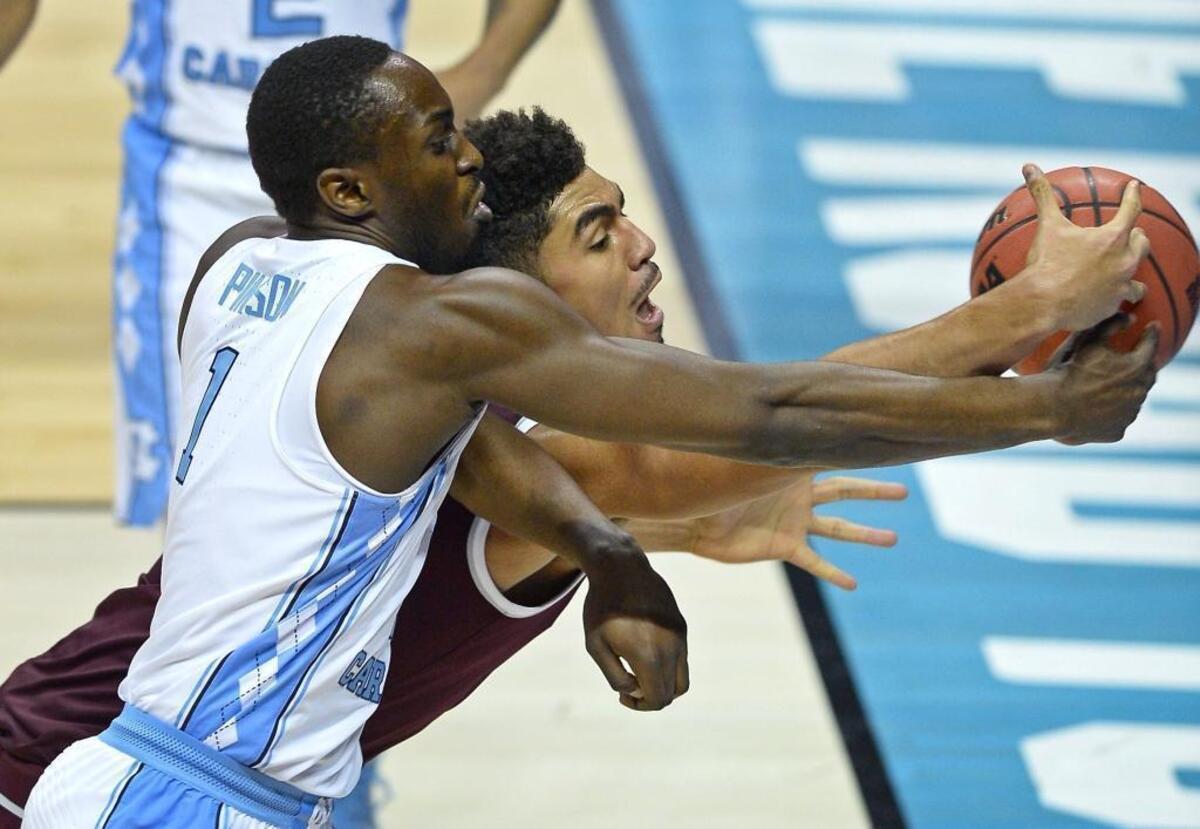 Texas A&M center Tyler Davis, right, fights fights for control of a loose ball with UNC Tar Heels forward/guard Theo Pinson, left, during Sunday’s NCAA tournament basketball game at the Spectrum Center. Pinson and Joel Berry, who played their final games as Tar Heels, will graduate with a career 14-3 record in the NCAA tournament, two Final Four appearances and one national championship.