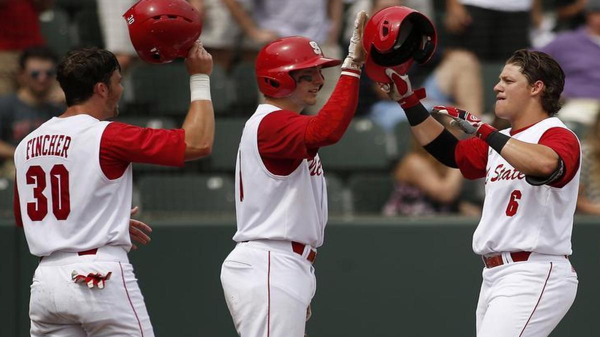 
N.C. State's Logan Ratledge (6) is met at home plate by teammates Jake Fincher, left, and Andrew Knizner, middle, after hitting a two-run home run in the fifth inning against Stony Brook at the Fort Worth Regional of the NCAA college baseball tournament in Fort Worth, Texas, on Friday, May 29, 2015. N.C. State won 3-0. 
