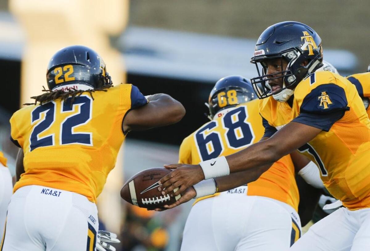 North Carolina A&T quarterback Lamar Raynard (7) hands the ball off to running back Marquell Cartwright (22) while facing the Charlotte 49ers during Saturday’s game at Jerry Richardson Stadium.