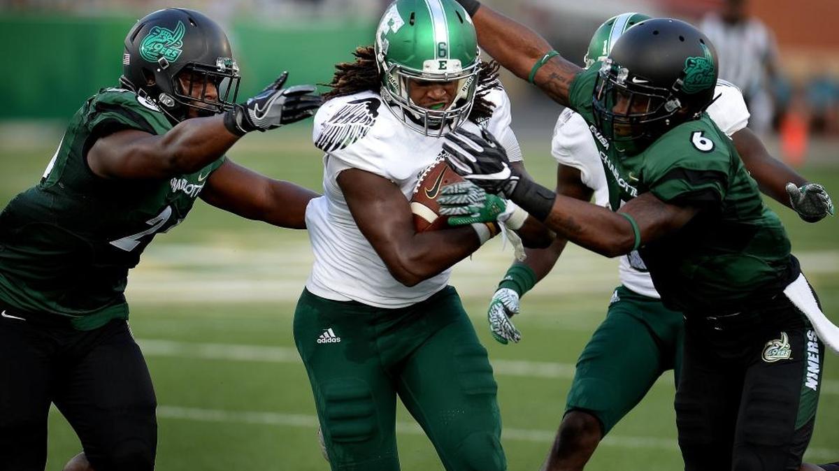 Eastern Michigan linebacker Jaylen Pickett, center, continues to fight for yardage after intercepting a pass by Charlotte 49ers quarterback Kevin Olsen during the second quarter Saturday at Richardson Stadium. Pickett had two interceptions and returned one for a touchdown.
