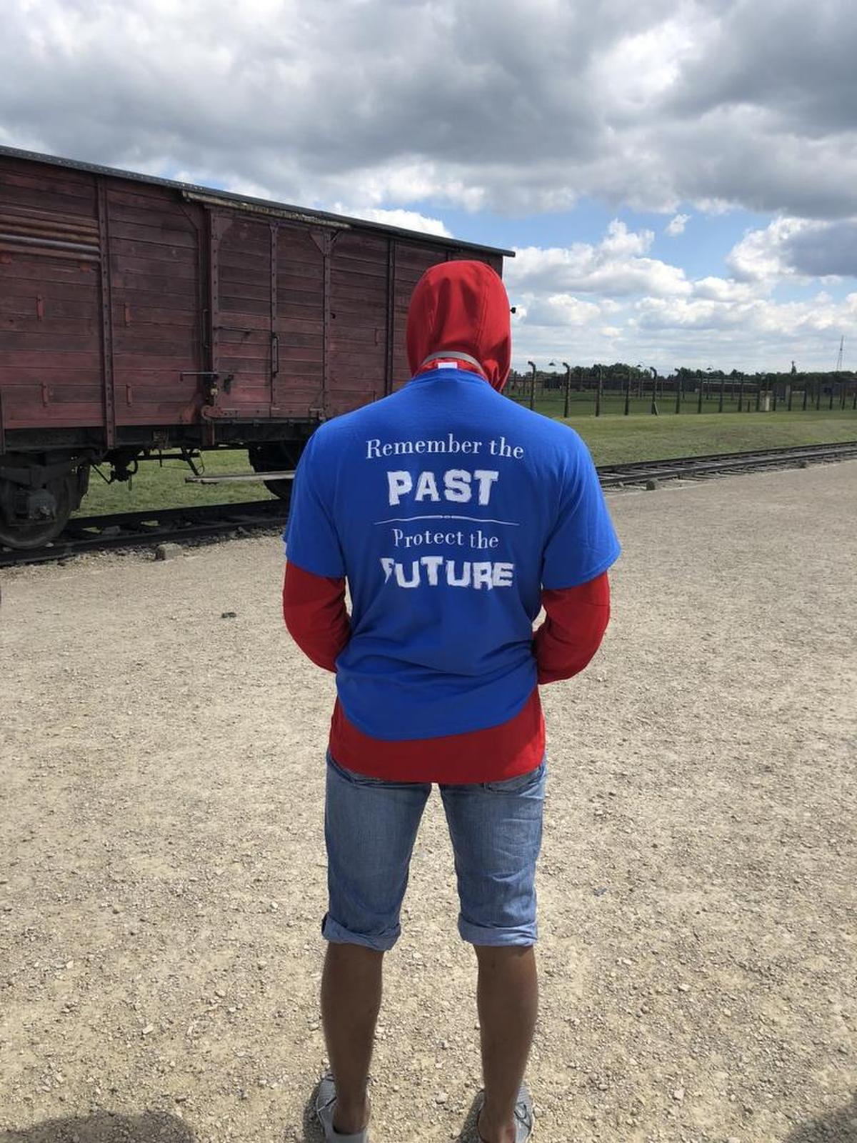 Davidson basketball player Carter Collins stands near a train car at Auschwitz/Birckenau, site of a World War II concentration camp.