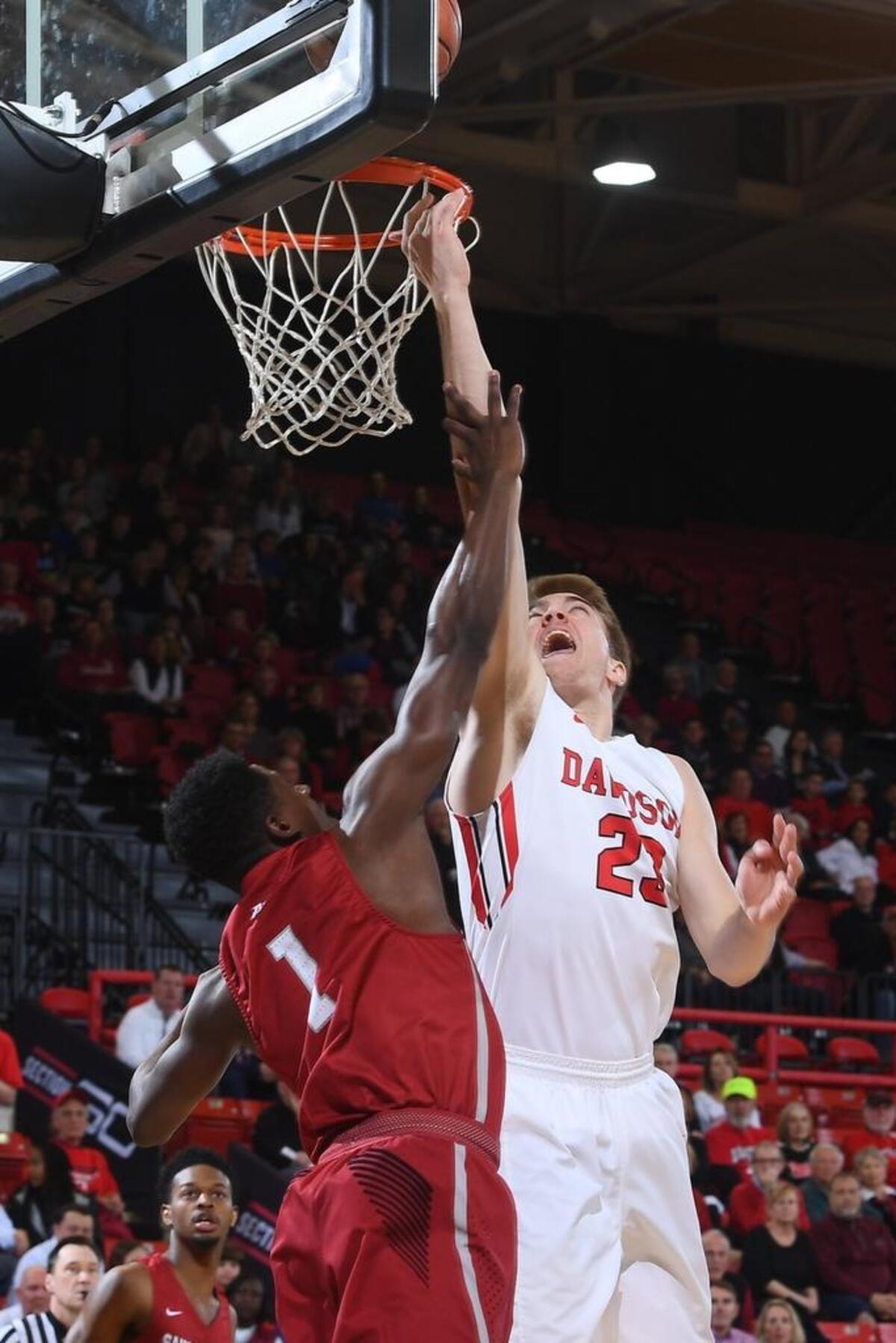 Davidson forward Peyton Aldridge (23) scores two of his game-high 32 points over Saint Joseph’s Shavar Newkirk early in first half of Tuesday’s Atlantic-10 men’s basketball game at Belk Arena. Davidson won 91-62.