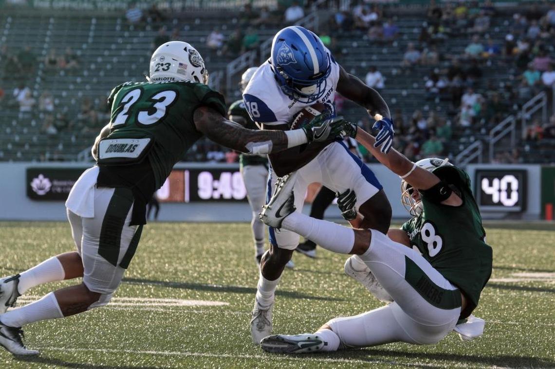 Charlotte 49ers cornerback Anthony Covington (23) and safety Ben DeLuca (28) tackle Georgia State receiver Penny Hart Saturday night at Richardson Stadium.